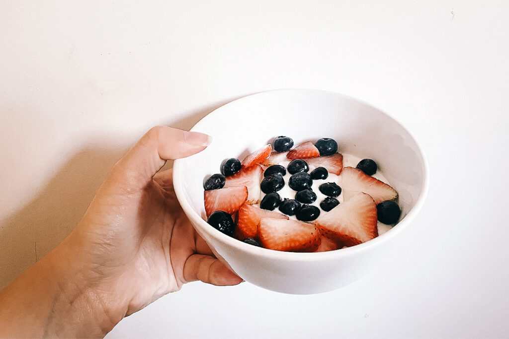 Holding up a bowl of yogurt and berries