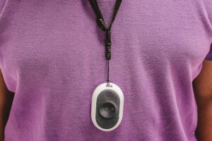 Medical Care Alert necklace around neck against a purple shirt.