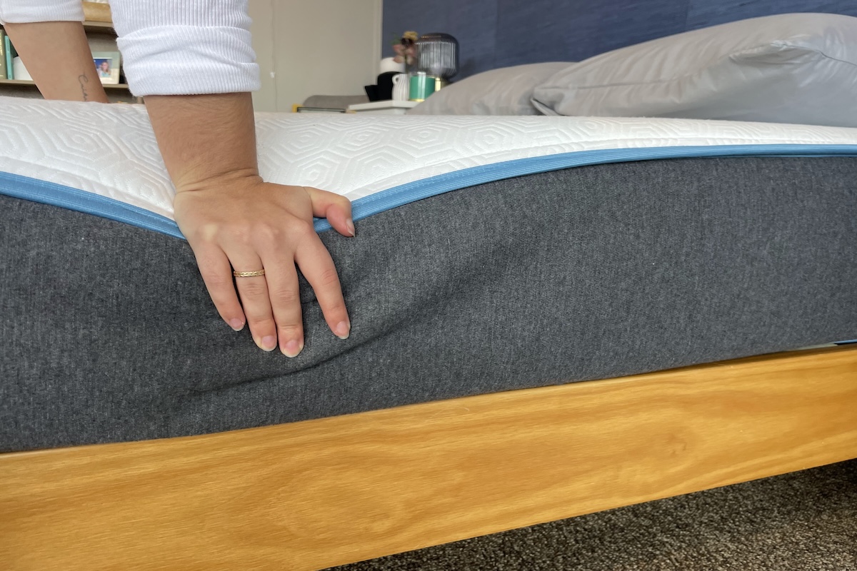 Our tester pushing down on a Bear mattress to test firmness and edge support