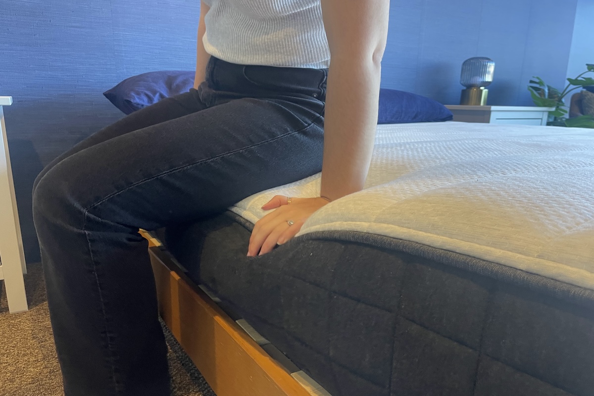 Our tester sitting down on a Helix mattress to test edge support