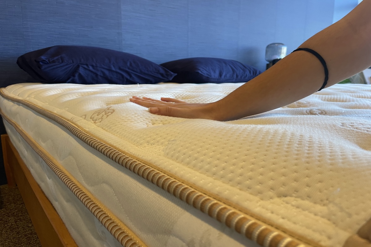 Our tester pressing down on the Saatva Classic mattress to test firmness