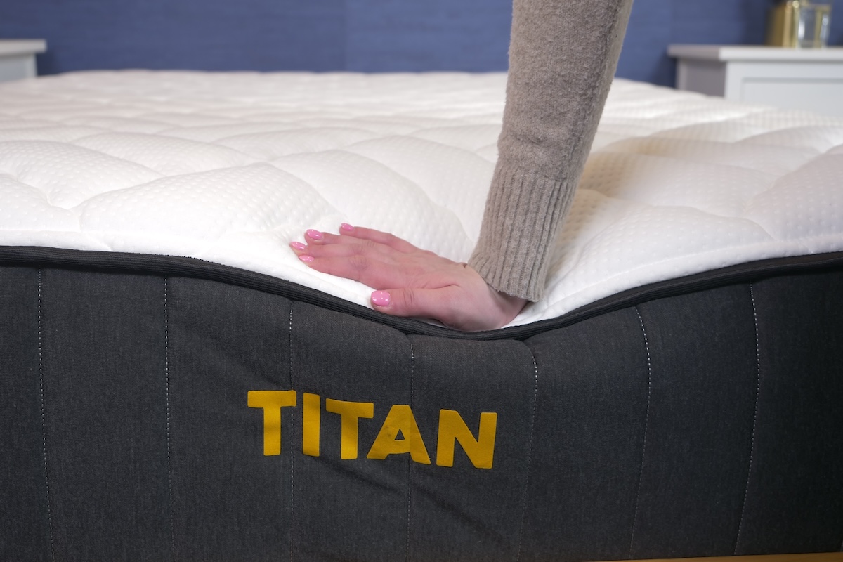 A hand pressing down on the edge of the Titan Plus in our testing facility