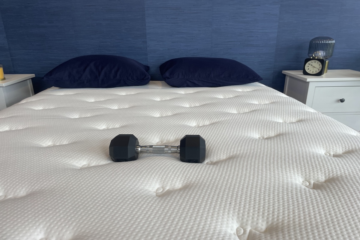 Brooklyn Bedding Signature Hybrid mattress being tested for bounce and motion isolation with a 10-pound barbell