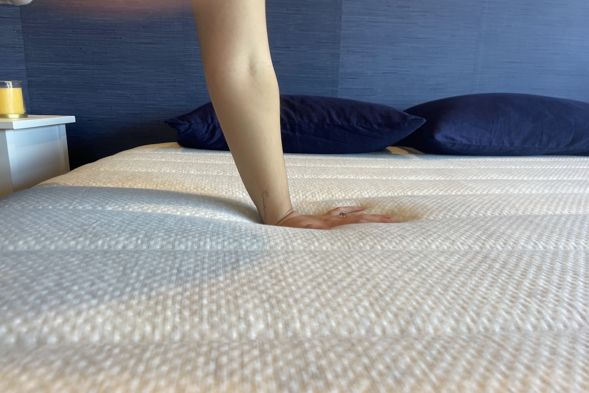 Hand pressing down on a Helix mattress cover