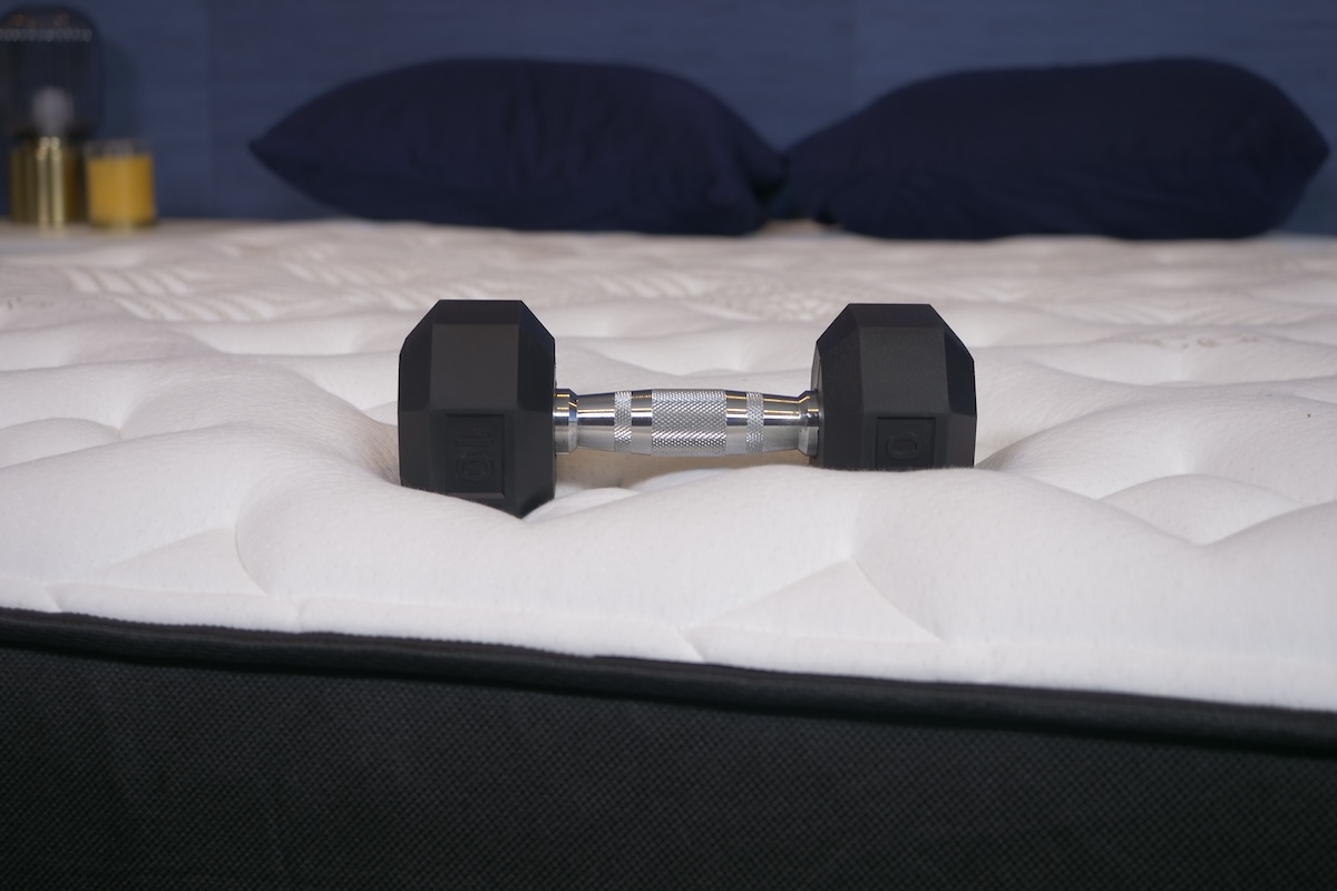 A 10-pound dumbbell resting on the Nolah Evolution mattress