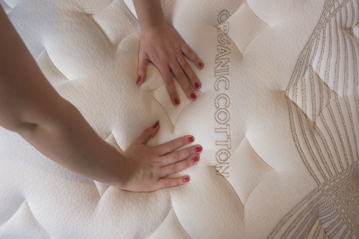 A woman’s hands press down on a Nolah mattress