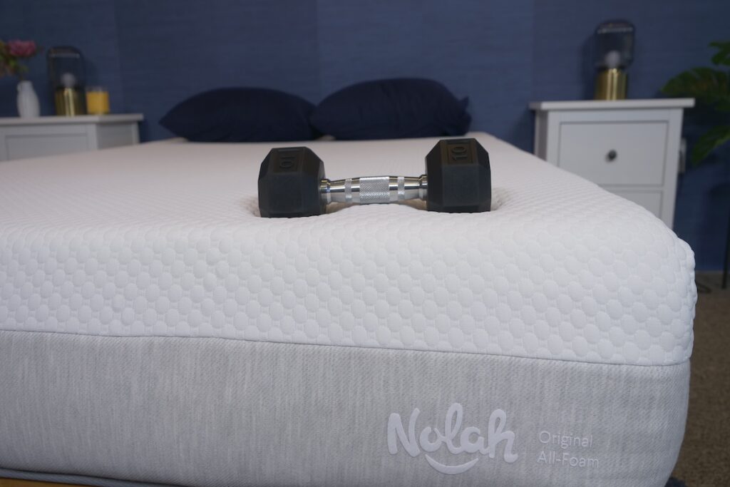 10-pound dumbbell rests on top of the Nolah Original All-Foam mattress