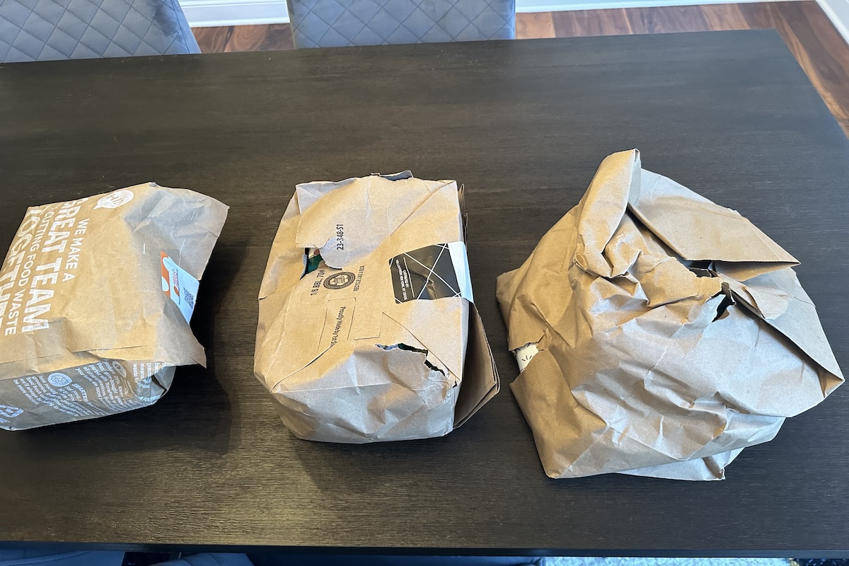 Three HelloFresh brown paper delivery bags with rips in some spots.

