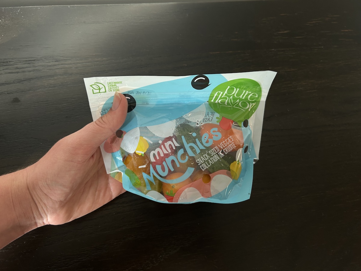 A hand holding veggie snacks in a bag from Hungryroot