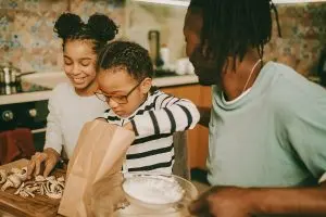 African American family preparing a meal together in a kitchen