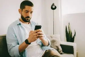 A man interacts with his mobile phone.