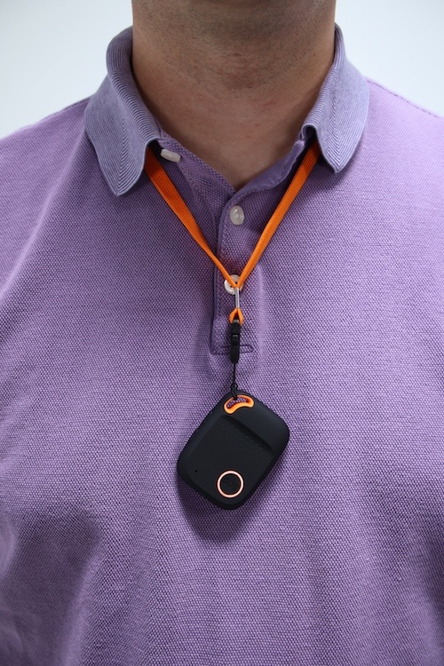 One of our testers wears the WellBe Medical Alert Necklace around his neck, resting against a purple shirt