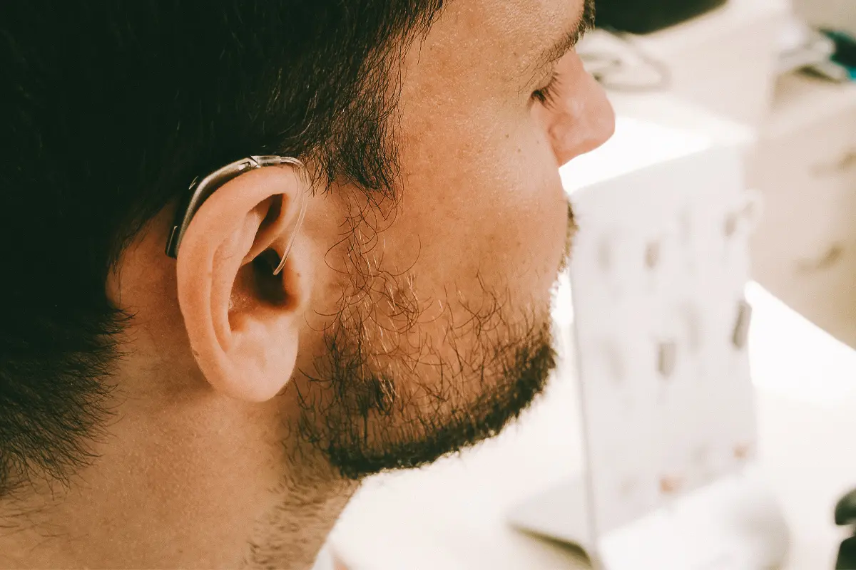 man smiles while being fitted for a Costco hearing aid